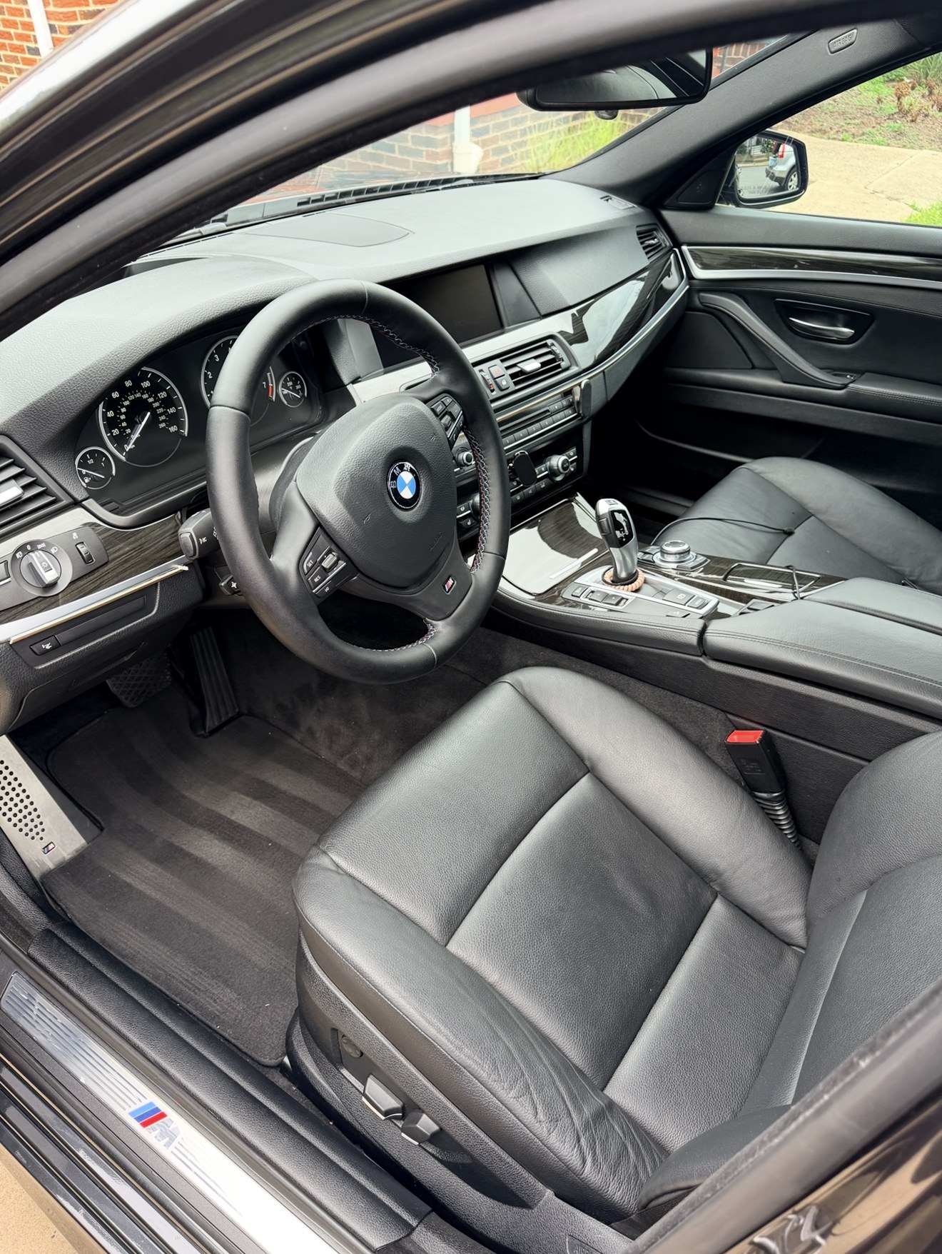 Detailed BMW 5 Series interior with clean black leather seats and carpets